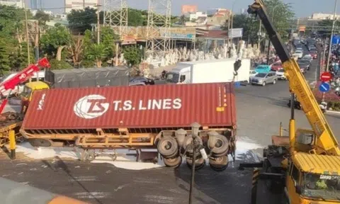 Xe container lật giữa vòng xoay ở TP.HCM, sơn trắng tràn mặt đường