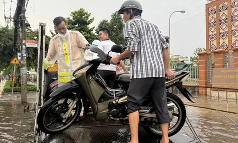 CSGT TP.HCM dùng xe đặc chủng giúp người đi đường vượt điểm ngập